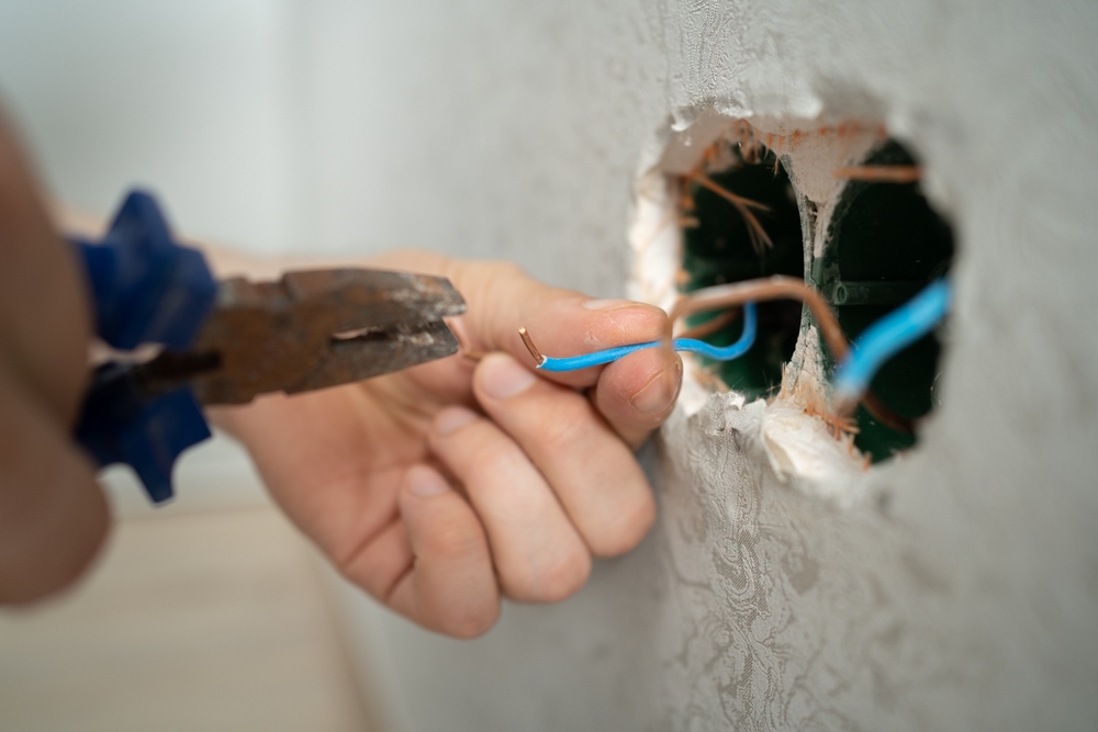 Man,Works,With,Electrical,Wires,Using,Tools,,Fixing,Socket,At
